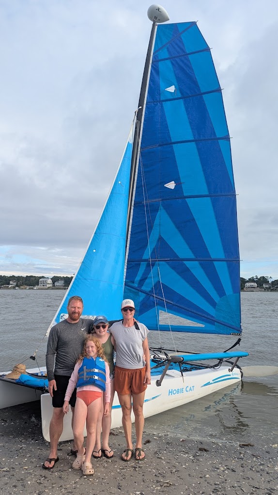Family posing beside the Hobie Cat after a sailing cruise